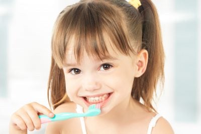 young girl brushing her teeth